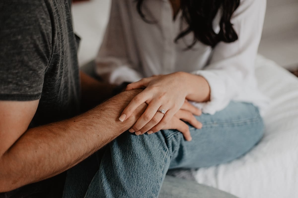 A woman holding her partner’s hand in comfort